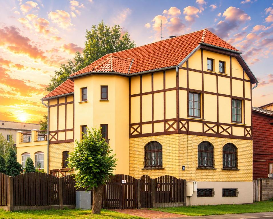 a yellow house with a red roof at Villand Hotel with Free Private Parking and Self Check In in Riga