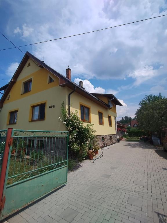 a yellow house with a gate in front of it at Apartmán Nebo in Turčianske Teplice