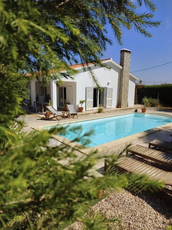 a villa with a swimming pool and a house at Endless Summer Surf House in Aljezur