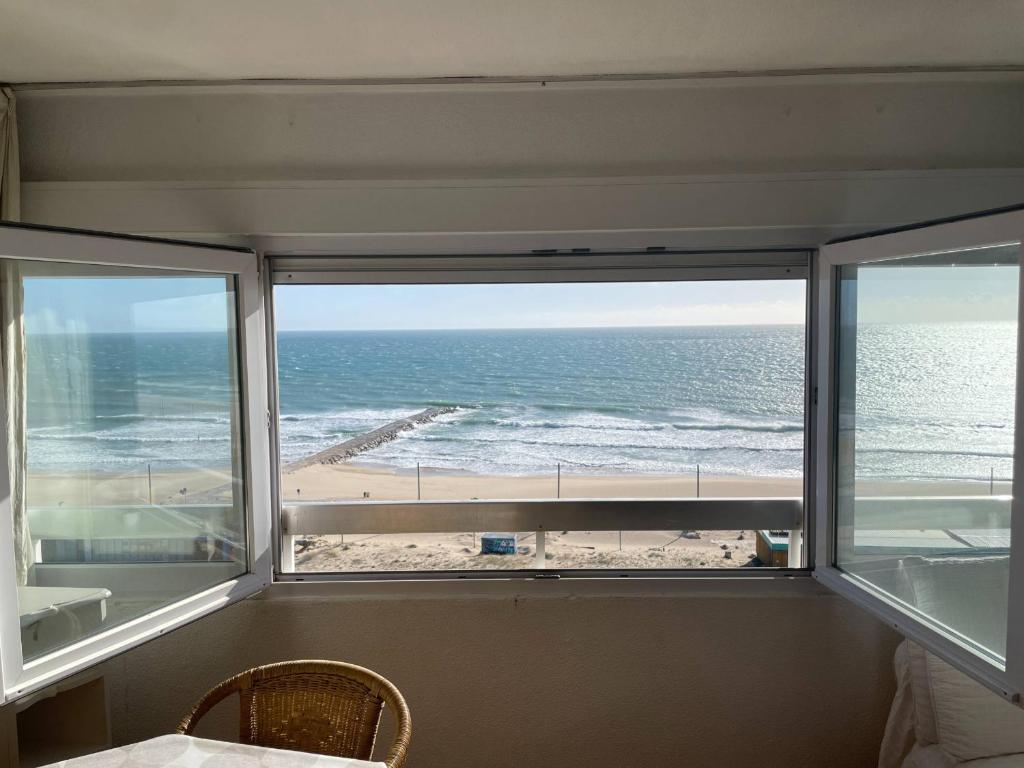 a room with a view of the beach from a window at Costa 010 in Setúbal