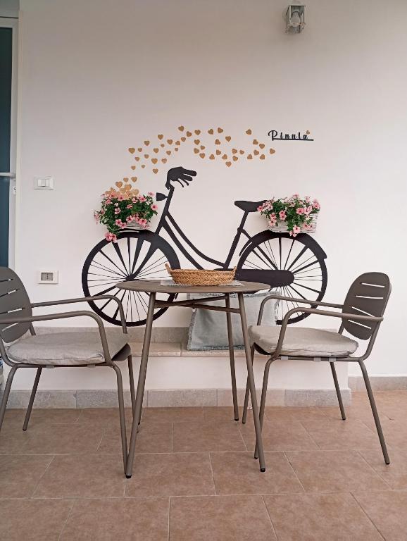 a bike sitting on a table with two chairs at B&B Pinulà in Maruggio