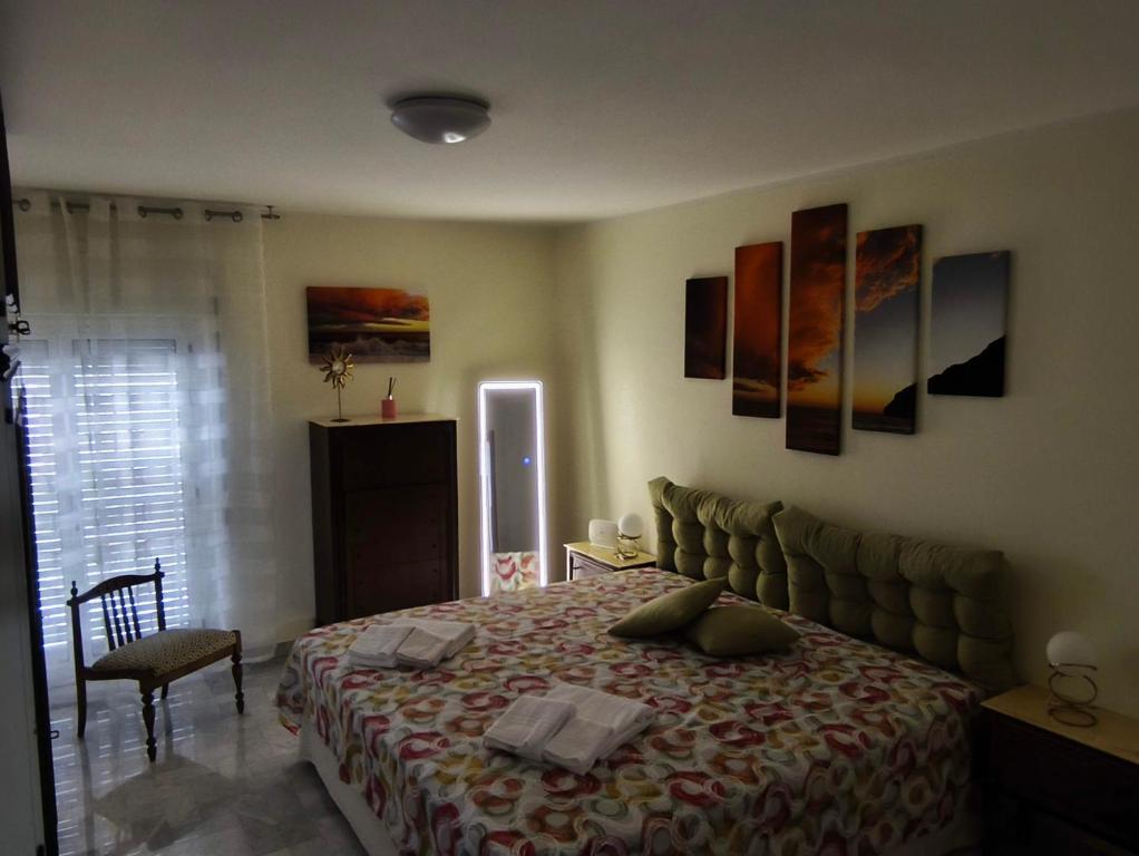 a bedroom with a bed and some paintings on the wall at Franca la Sarta House in Castellana Grotte
