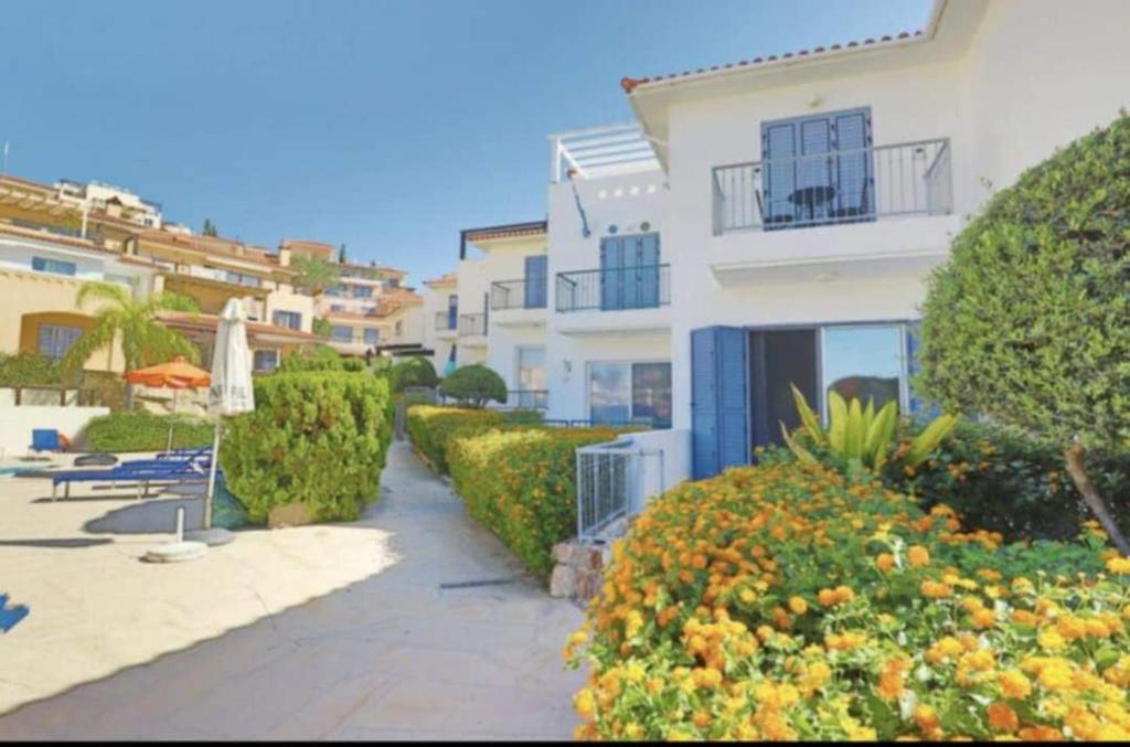 a pathway leading to a building with bushes and trees at Pegeia Sun in Peyia