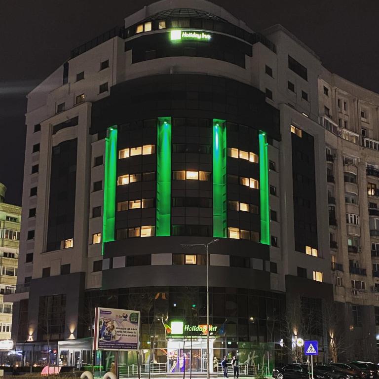 a building with green lights on the side of it at Holiday Inn Bucharest - Times by IHG in Bucharest
