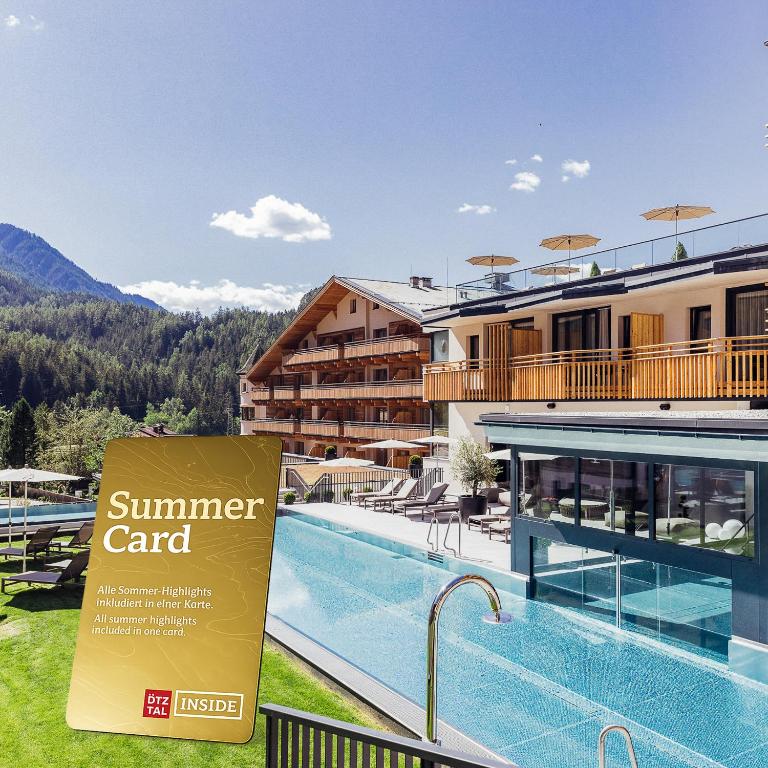 a sign in front of a hotel with a swimming pool at Hotel habicher hof - Your 4-Star Superior Wellness Hideaway in Oetz
