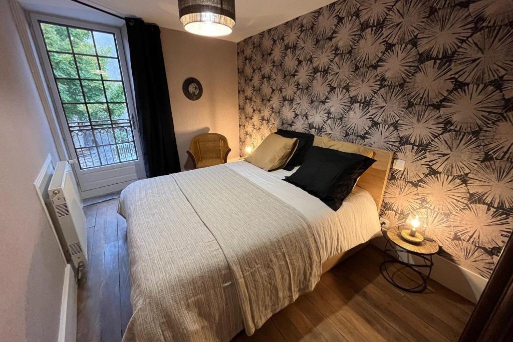 a bedroom with a large bed and a wall at Logis du mont in Saint-Sernin-du-Plain