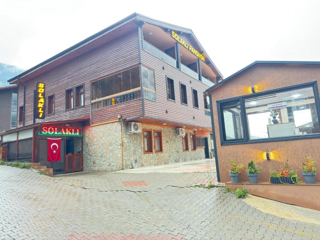 a building with a sign on the side of it at Solaklı Pansiyon in Uzungöl