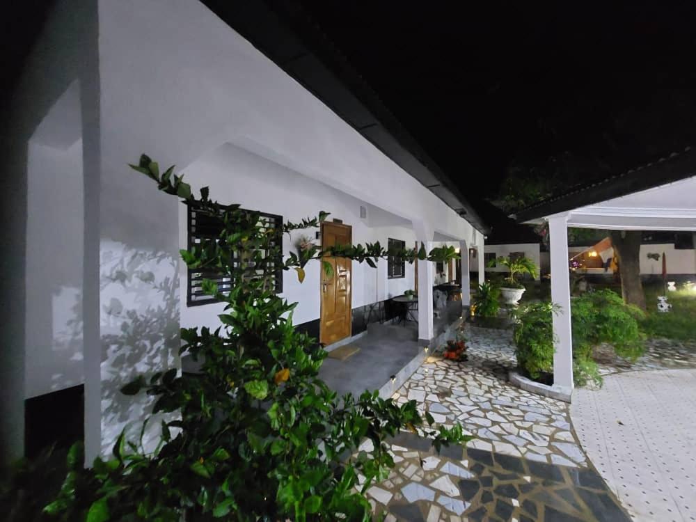 a white building with a door and a courtyard at Maria's place in Tujering