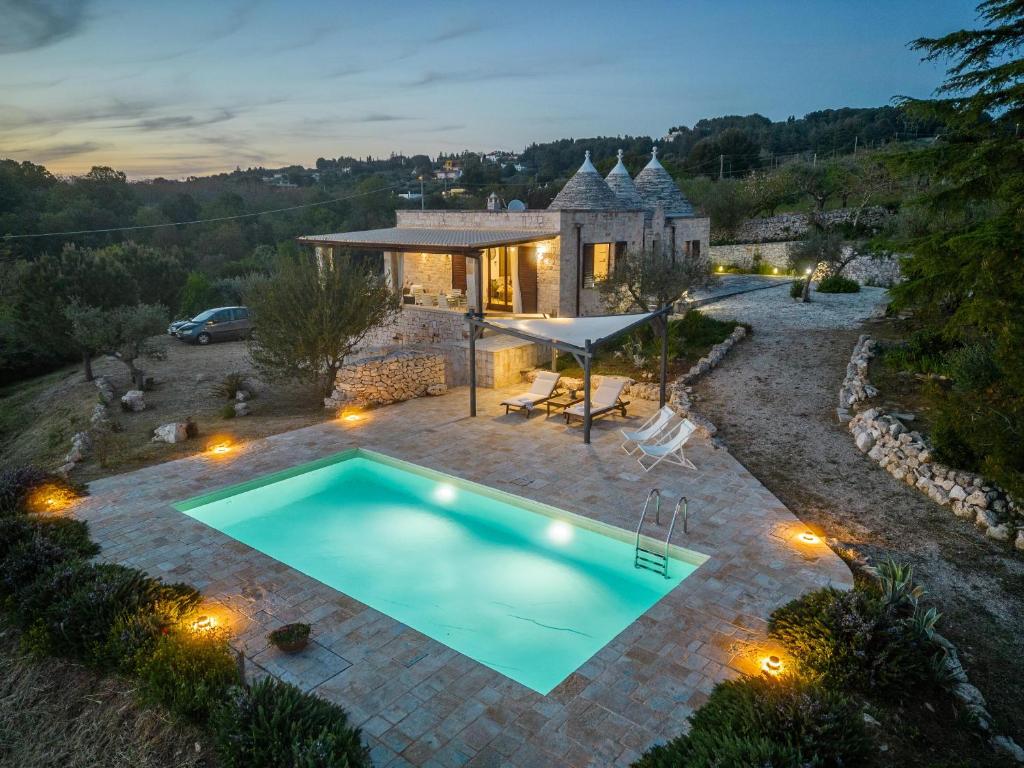 a villa with a swimming pool in front of a house at Trulli Oasis in Noci
