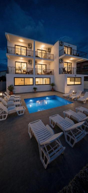 a swimming pool with lounge chairs and a building at Azur Apartments Bar in Bar