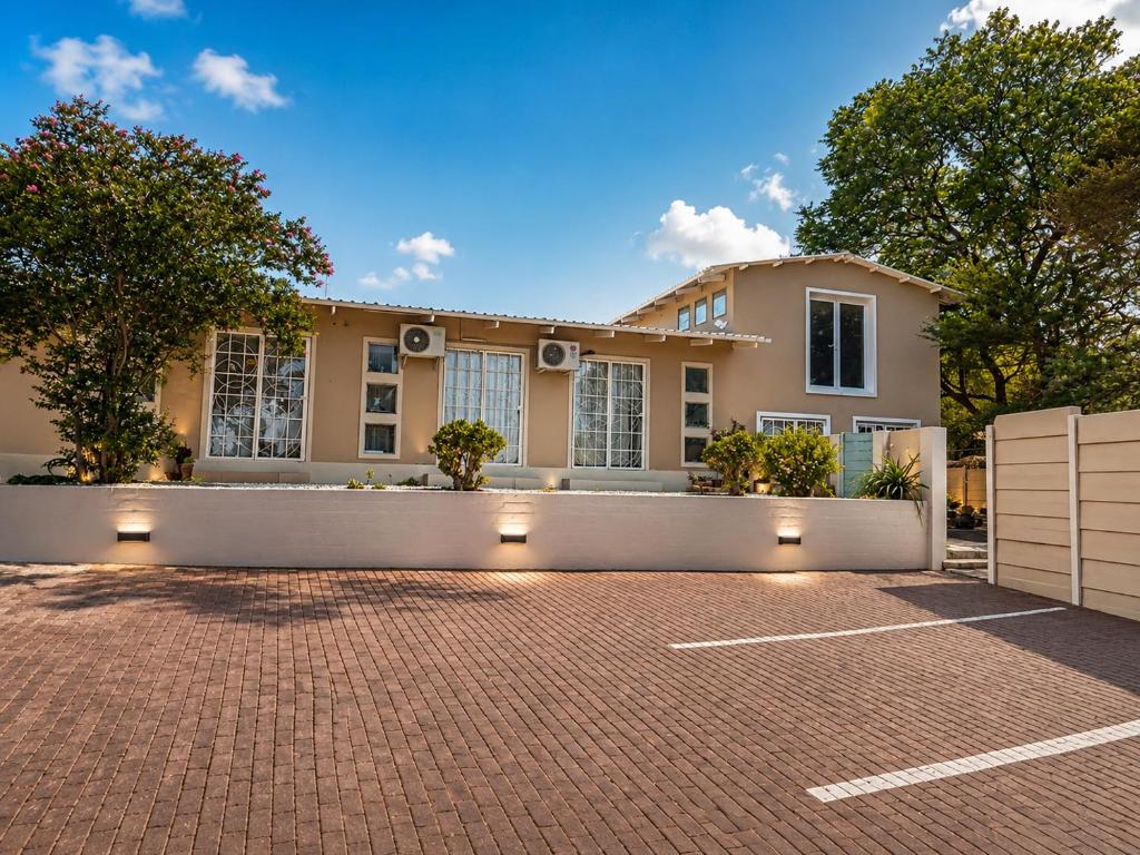 a large house with a brick parking lot at Suider Ozias Self Catering in Windhoek