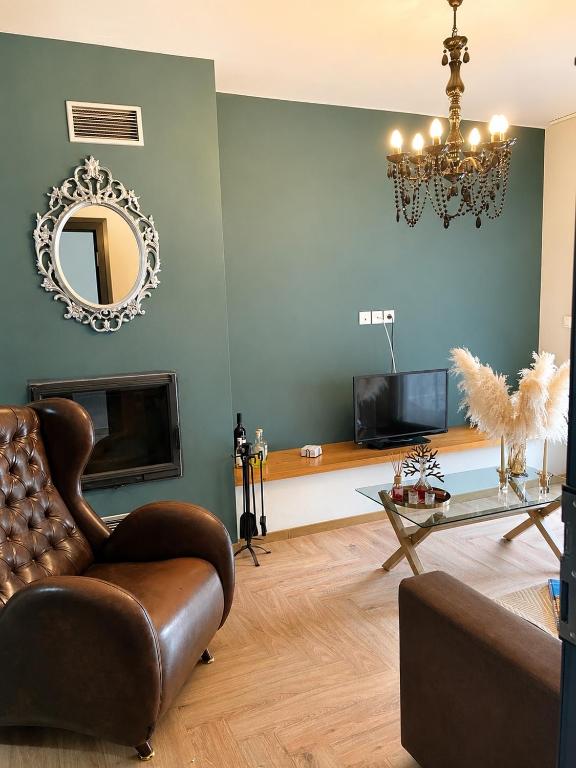 a living room with a chair and a mirror at Βίλα Βασιλική in Elassona