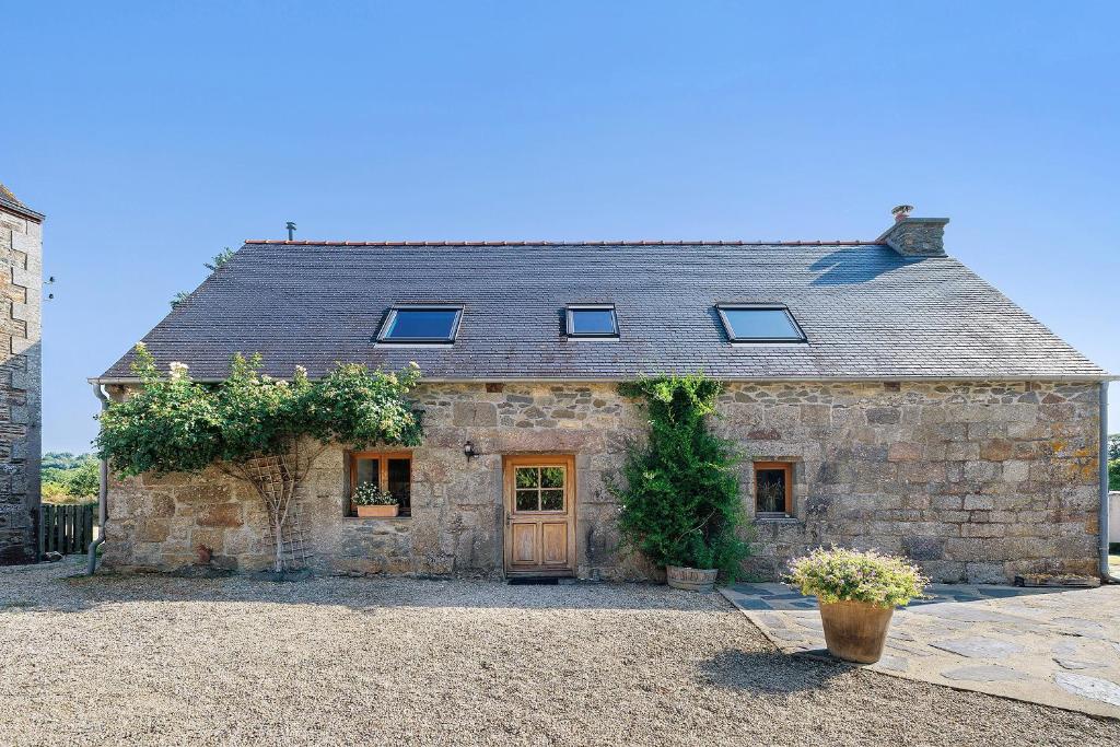 an old stone house with a door and windows at Longère Colpernou in Plouguernével