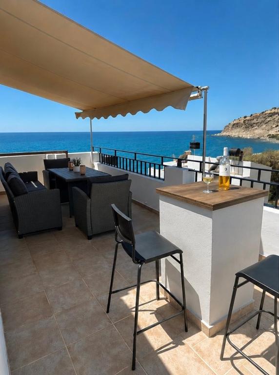 a patio with a table and chairs and an umbrella at Thea in Myrtos