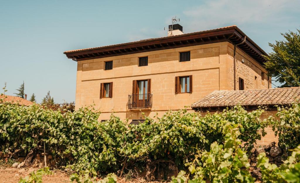 a brick building with a balcony on the side of it at La Venta de Bodegas Ostatu in Samaniego