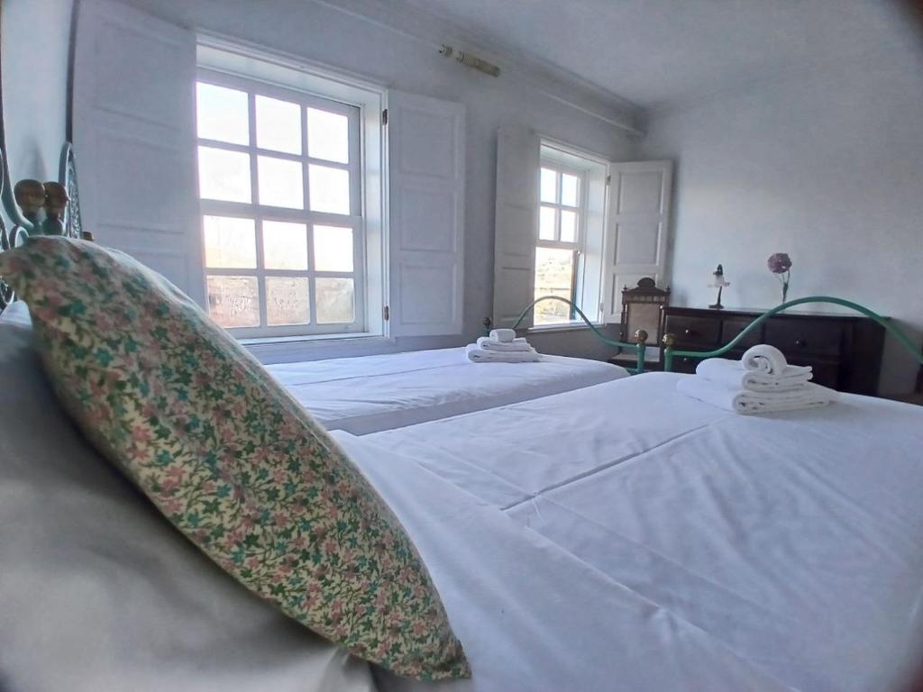 a bedroom with two beds with white sheets and a large window at Casa Kilowatt - Amarante - Quarto 2 in Amarante