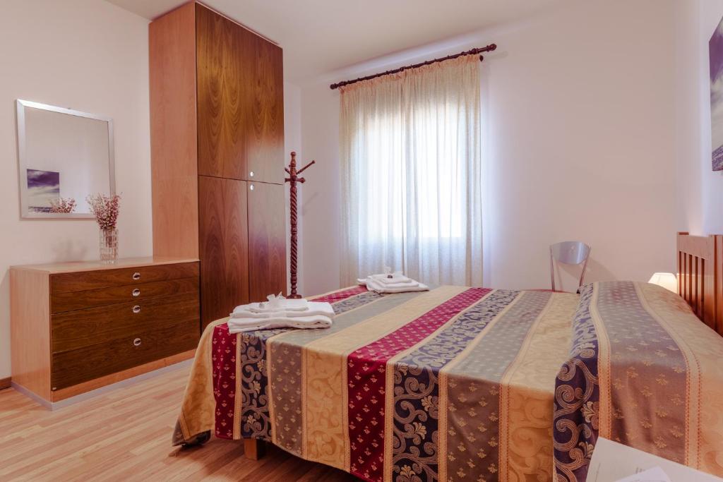 - une chambre avec un lit, une commode et une fenêtre dans l'établissement Le Terrazze, à Follonica