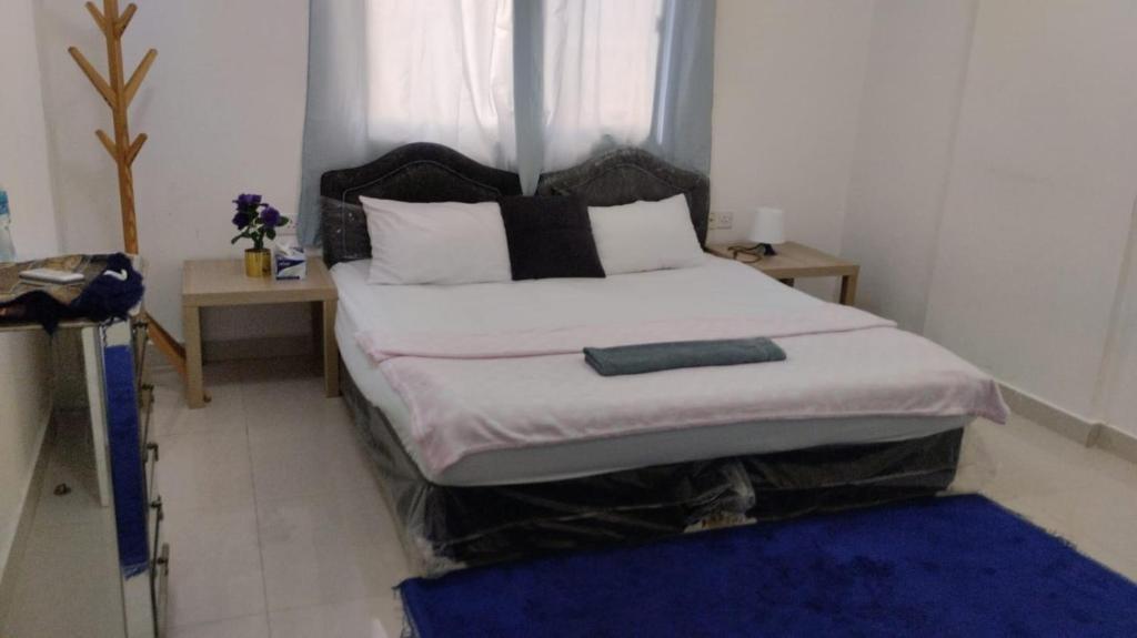 a bedroom with a large bed with a window at RelaxAlkhuwirHostel in Muscat