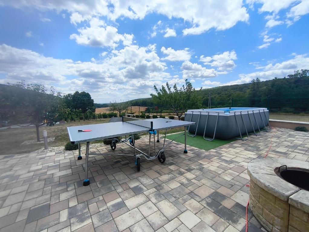 a ping pong table sitting on top of a patio at Eplényi Apartmanház in Eplény