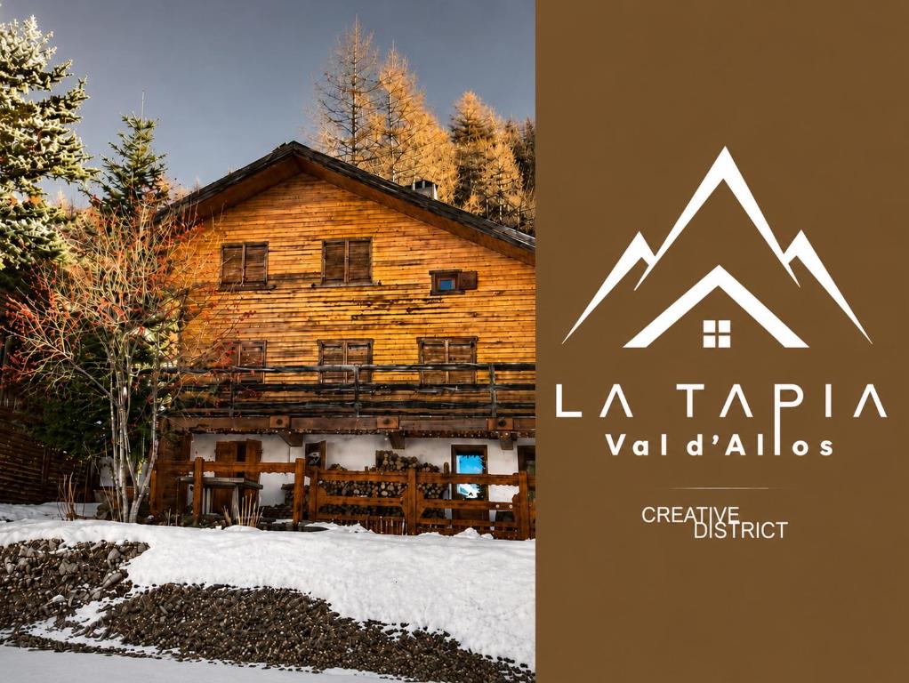 a log cabin in the snow with a sign in front at La Tapia in La Foux d'Allos