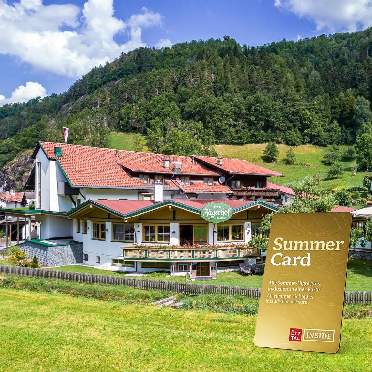 a building with a summer card sign in front of it at Hotel Jägerhof Ötz in Oetz