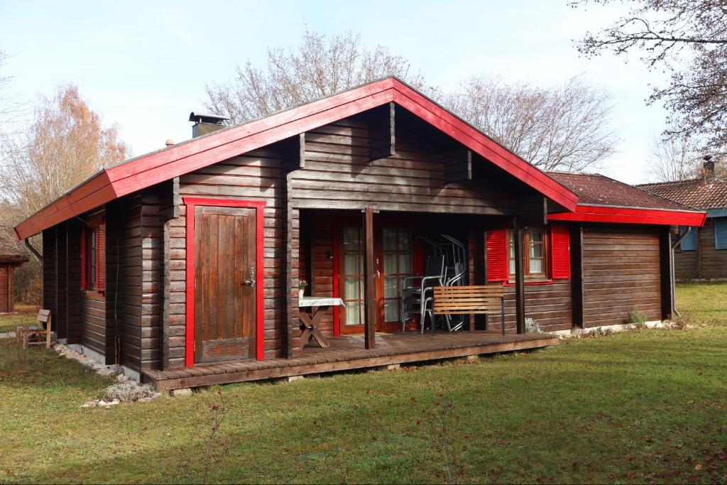 a small wooden cabin with a red roof at Ferienhaus Neckar 70 in Hayingen