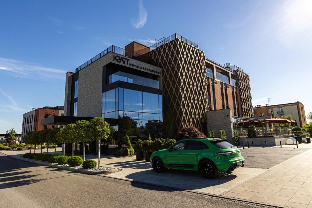 Ein grünes Auto parkte vor einem Gebäude in der Unterkunft Hotel Kraft in Kraśnik