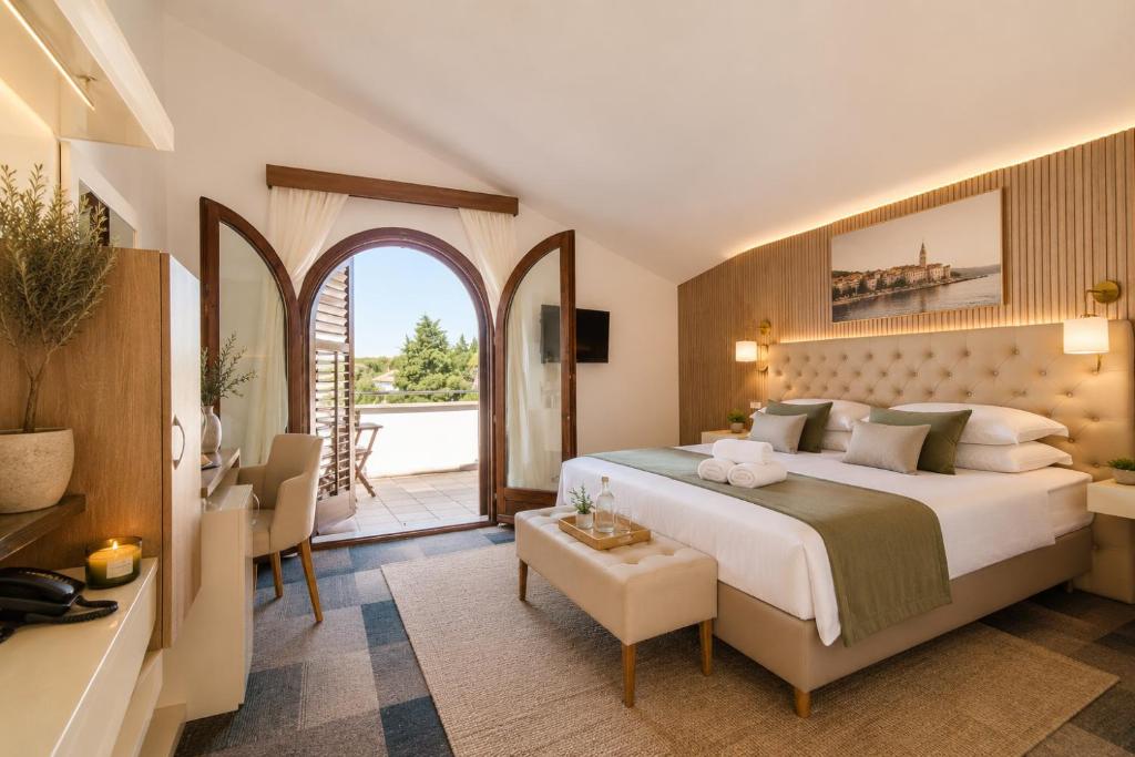 a bedroom with a large bed and a living room at Pansion Vila Vrsar in Vrsar
