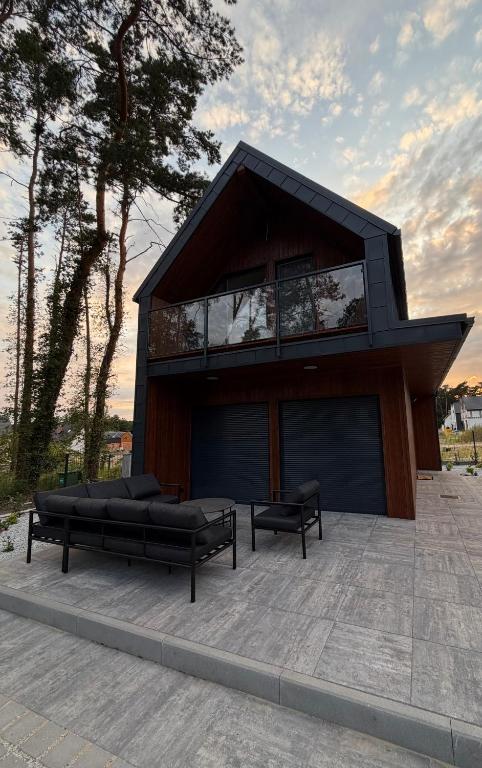 a house with two black benches in front of it at Black House in Sława