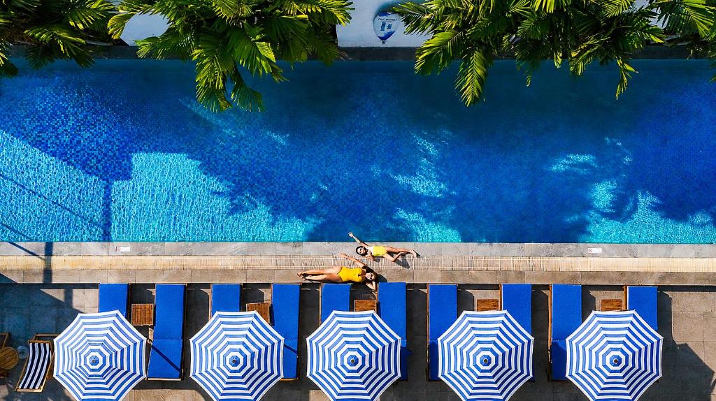 a person laying on a bench next to a swimming pool at Radisson Suites Bangkok Sukhumvit in Bangkok