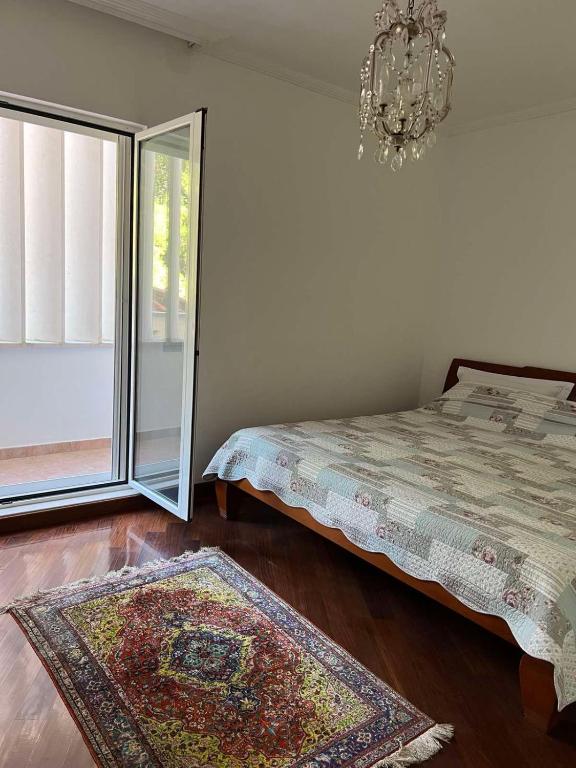 a bedroom with a bed and a chandelier at Nikola CG in Sutomore