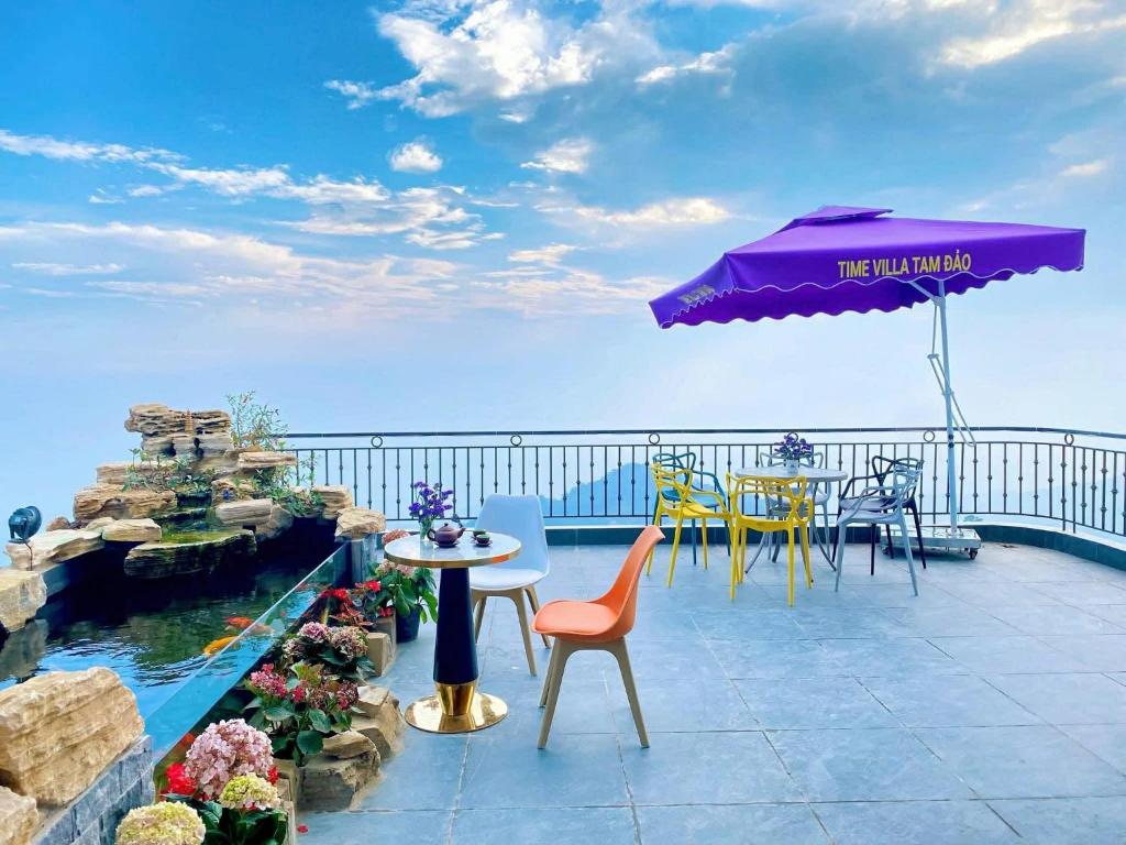 a patio with a table and chairs and an umbrella at Gấu Home Tây's in Tam Ðảo