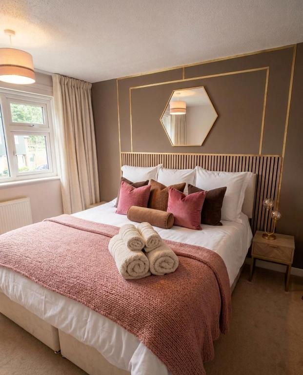 a bedroom with a large bed with towels on it at Modern Large 5-Bed-2 Baths-Parking-Great for Groups-Contractors-Families-Royal Leamington Spa-Warwickshire-By The Home Makers Hub in Leamington Spa