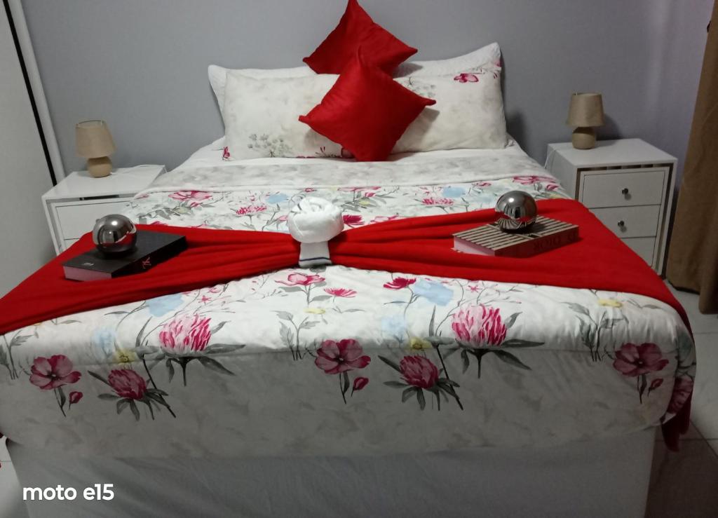 a bed with a red blanket on top of it at Green Harvest BnB in Newmansford