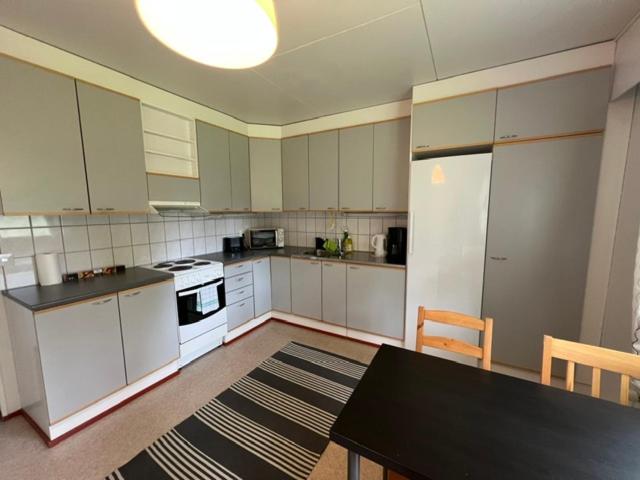 a kitchen with white cabinets and a black table with a black table sidx sidx sidx at Ravikatu, Oulainen, in Oulainen