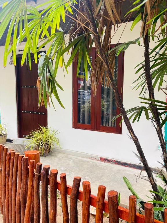 a wooden fence in front of a house with a window at Coastal Bliss in Dickwella