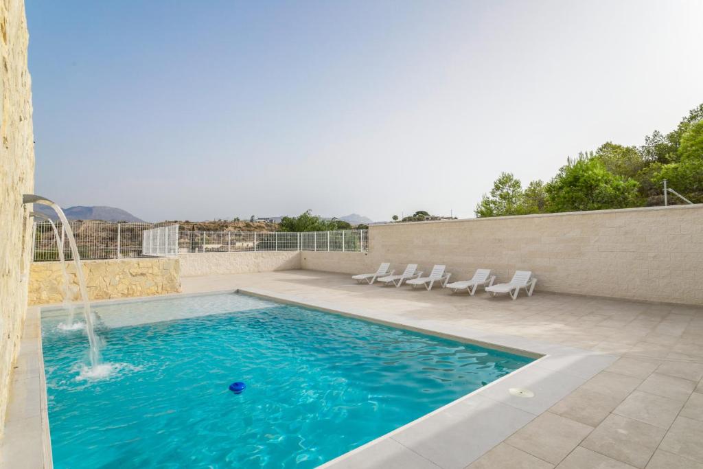 a swimming pool with chairs and a water fountain at Bender House in Moralet