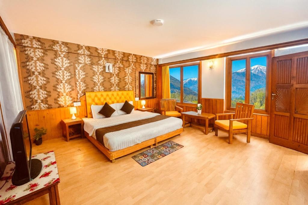 a hotel room with a bed and a television at The Ganga lodge, Manali - Affordable Luxury Stay Near Mall Road Manali in Manāli