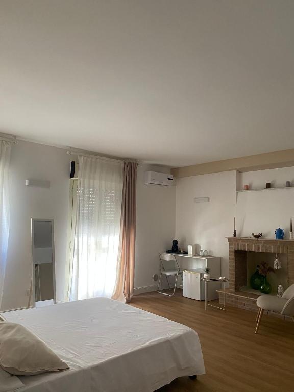 a white bedroom with a bed and a fireplace at Residenza Vittoria in Petacciato