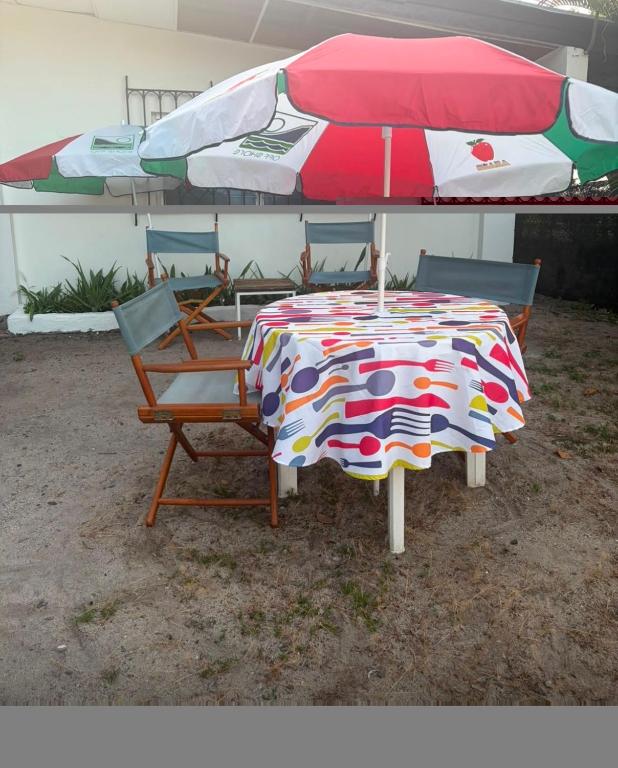 a table with an umbrella and two chairs under it at Yayi Maria in Río Hato