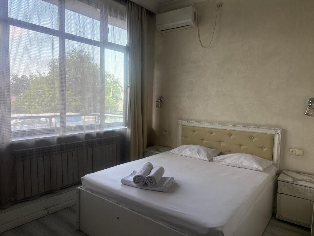 a bedroom with a bed with two towels on it at Rodnik in Almaty