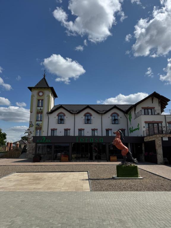 a large white building with a clock tower at Hotel Kazak Club in Chişinău