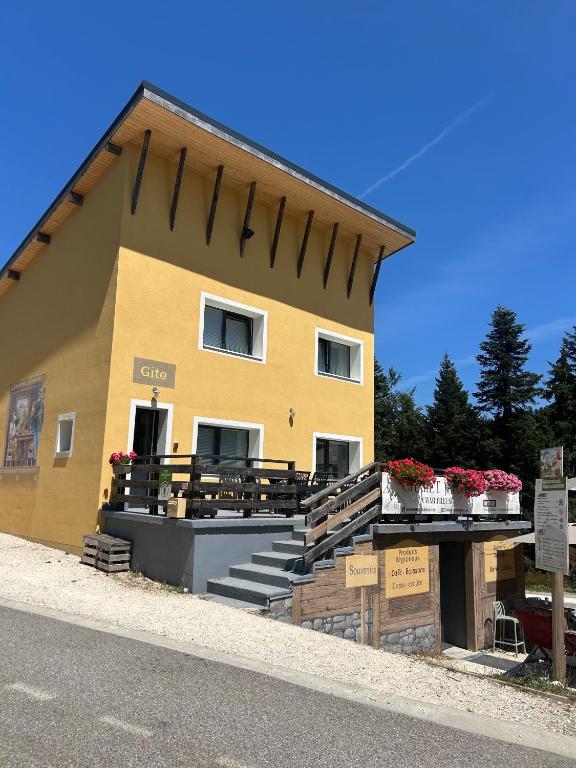 a yellow building with some flowers in boxes on it at Chalet Jaune Le GRAND SOM in Sarcenas