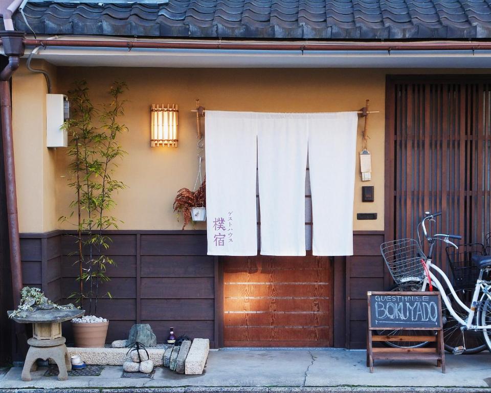 una casa con una cortina blanca en la puerta en Guest House Bokuyado, en Kioto
