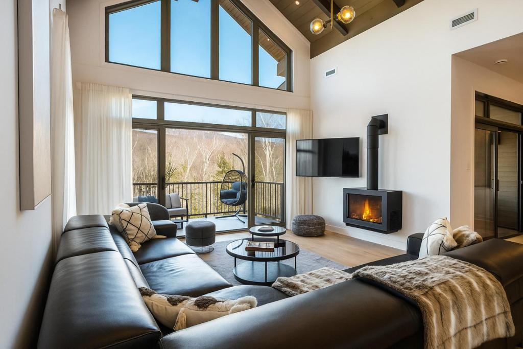 a living room with a leather couch and a fireplace at Tremblant Prestige - Verbier 3-201 in Mont-Tremblant