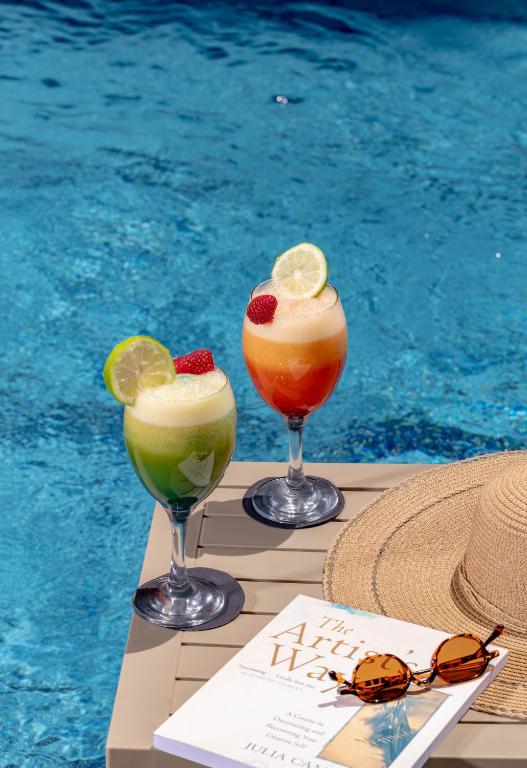 two cocktails on a table next to a swimming pool at Idou Anfa Hôtel & Spa in Casablanca