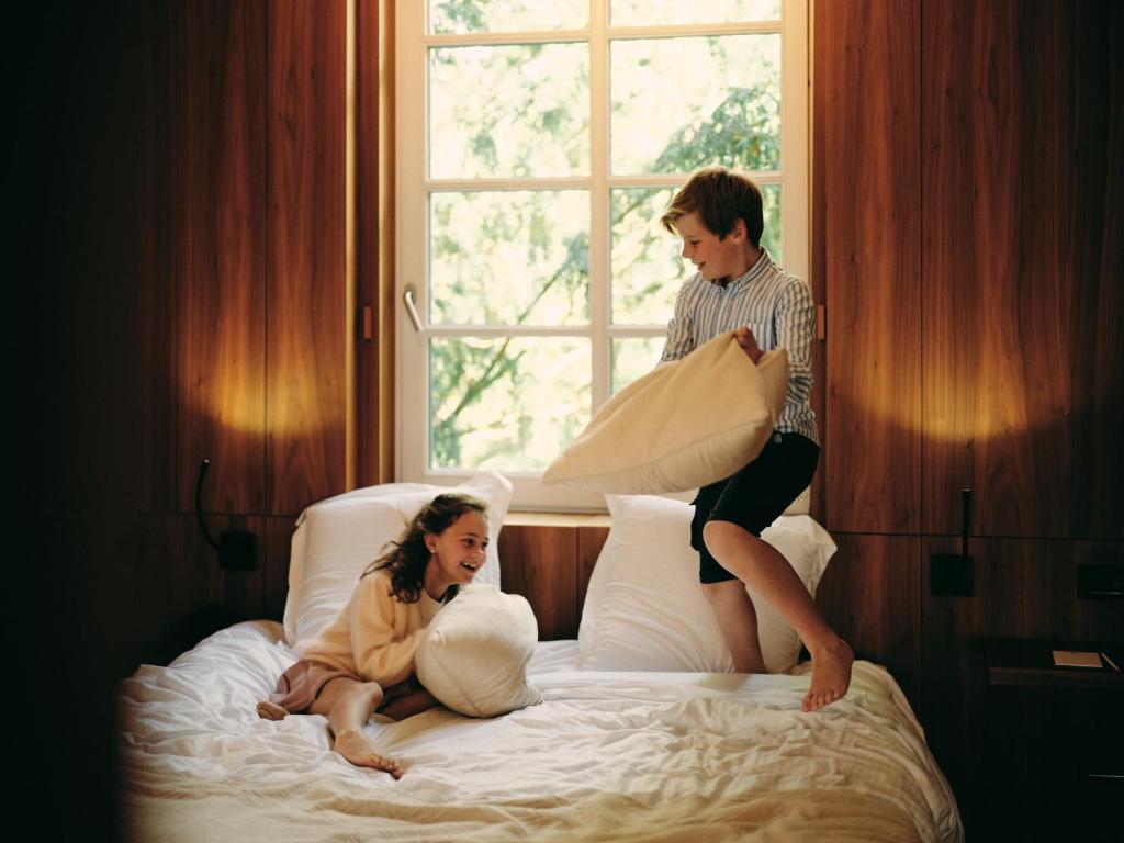 Ein Mann und eine Frau sitzen auf einem Bett in der Unterkunft Hotel Messeyne in Kortrijk