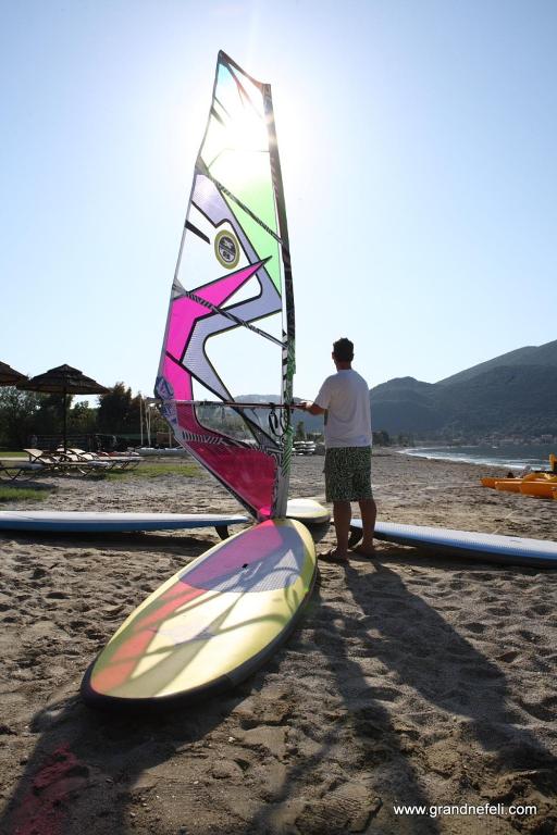 a man standing next to a kite on the beach at Grand Resort nefeli in Vasiliki