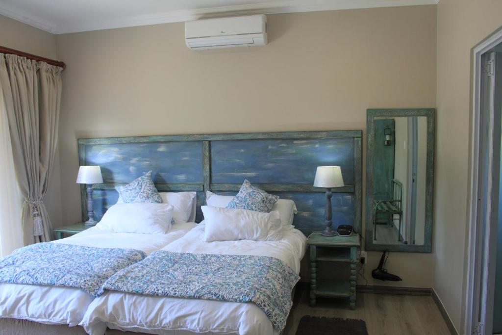 a bedroom with a large bed with a large headboard at The Alchemist's Place in Oudtshoorn