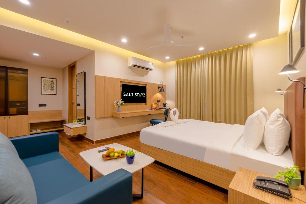 a hotel room with a bed and a couch at Saltstayz Premier - Noida Sector 15 in Noida